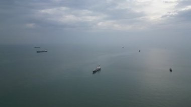 Bir grup tekne okyanusta. Su sakin ve gökyüzü bulutlu. Görünürde en az beş tekne var.