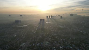 Larkin şehrinin arka planında sisli bir gökyüzü ve güneşi var. Güneş batıyor ve gökyüzü puslu.