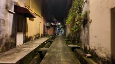 Batu Pahat, Johor, Malezya - 30 Mayıs 2024: Ortasında sokak lambası olan dar bir ara sokak. Ara sokak karanlık ve boş.