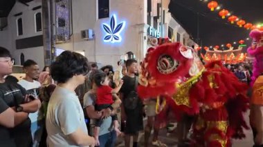 George Town, Penang, Malezya - Şubat 09 2024: Renkli aslan dansı tapınak kutlamasında kalabalığı eğlendiriyor.