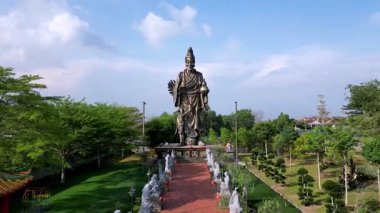 Yong Peng, Johor, Malezya - 30 Mayıs 2024 Tian Pao Kong Tapınağı 'nın devasa 20 metrelik Ji Gong heykelinin yemyeşil tapınak zemininde havadan çekimi.