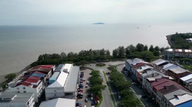 Pontian, Johor, Malaysia - Jun 03 2024: A town with sea in the background. There are buildings and cars in the town