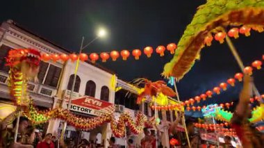 George Town, Penang, Malaysia - Jan 27 2024: A dragon is being carried by a group of people. The people are carrying the dragon on a street during Kwong Wah Yit Poh Chinese New Year Gala