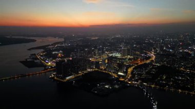 Johor Bahru, Johor, Malaysia - Jul 18 2024: City lights begin to twinkle as sunset fades over JB town from a bird-eye view.