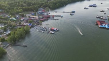 Kong Kong, Johor, Malaysia - Apr 29 2024: A boat is in the Sungai Johor near a town. The water is green