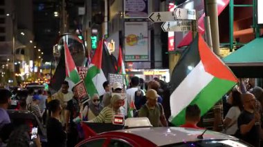 Bukit Bintang, Kuala Lumpur, Malaysia - Oct 26 2024: A peaceful sePeople flows through the town, waving Palestine flags with pride.