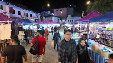 Johor Bahru, Johor, Malaysia - Jul 11 2024: Crowds wander through Pasar Karat under glowing night lights in Johor Bahru.