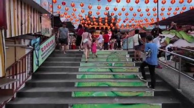 Bayan Lepas, Penang, Malaysia - Feb 14 2024: A group of people are walking up a set of stairs at snake temple