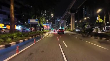 Bukit Bintang, Kuala Lumpur, Malaysia - Jun 17 2024: POV car is driving down a street at night.