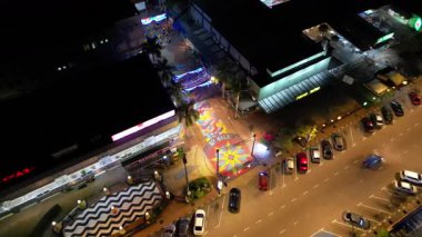 Batu Pahat, Johor, Malaysia - May 29 2024: A street with a lot of cars parked on it. The street is lit up at night at Jalan Rahmat