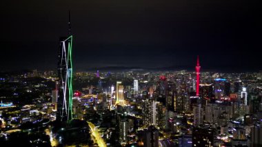 Bukit Bintang, Kuala Lumpur, Malaysia - Jun 17 2024: A town skyline with a tall building lit up at night