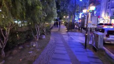 Johor Bahru, Johor, Malaysia - Jul 11 2024: A woman and a child walk down a sidewalk in a city