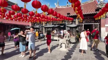 George Town, Penang, Malaysia - Feb 04 2024: A devotee lights incense and pray at Goddess of Mercy Temple.