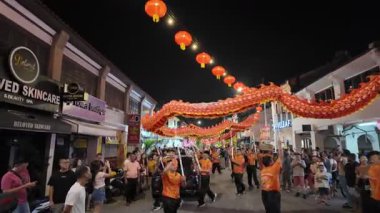 George Town, Penang, Malaysia - Feb 09 2024: Dancers animate the dragon in glowing nighttime street during Chinese New Year