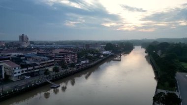 Kota Tinggi, Johor, Malaysia - May 29 2024: Sungai Johor river runs through a town with a cloudy sky above.