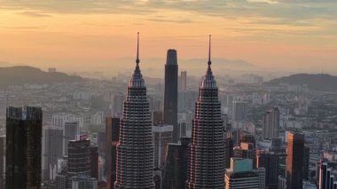 Bukit Bintang, Kuala Lumpur, Malaysia - Dec 14 2024: The Kuala Lumpur cityscape glows under the golden hour as the camera soars past KLCC.