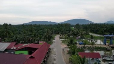 Batu Pahat, Johor, Malaysia - Jun 02 2024: A road with houses on both sides. The houses are red and have roofs at Sungai Ayam