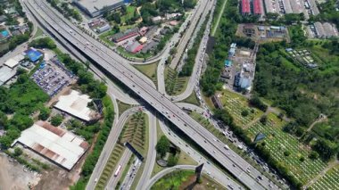 Johor Jaya, Johor, Malaysia - Jul 18 2024: A highway with a of traffic and a cemetery in the background at Johor Jaya