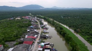 Batu Pahat, Johor, Malaysia - Jun 02 2024: A river, town with houses and boat at Sungai Ayam