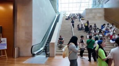 Singapore - Jul 17 2024: A group of people are walking up a set of stairs in National Gallery Singapore