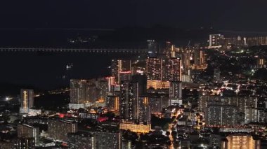 George Town, Penang, Malaysia - Dec 31 2024: City at night with a bridge in the background. The town is lit up with lights and the sky is dark