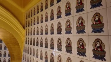 Ayer Itam, Penang, Malaysia - Feb 04 2024: A wall covered in tiles with Buddha statues at Kek Lok Si Temple
