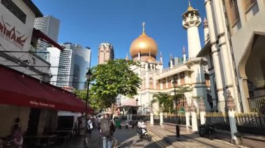 Kampung Glam, Singapore - Jul 11 2024: A street with a red awning and Sultan Mosque with a gold dome on top with a dome on top