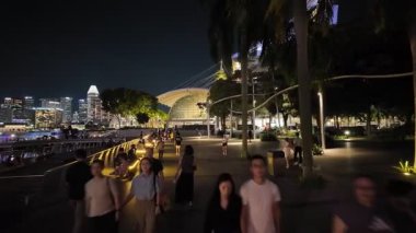 Marina Bay, Singapore - Jul 09 2024: A group of people walking on a sidewalk in a city at Marina Bay Sand.