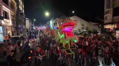 George Town, Penang, Malaysia - Feb 24 2024: A group of people are walking down the street with a dragon float during Poh Hock Seah Grand Float Procession