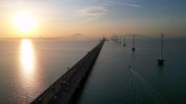 Gelugor, Penang, Malaysia - Jun 11 2024: Penang Bridge with a sunrise in the background. There are cars on the bridge