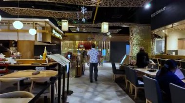 Bukit Bintang, Kuala Lumpur, Malaysia - Dec 14 2024: Restaurant with people sitting at tables and a man walking at food court Lot 10