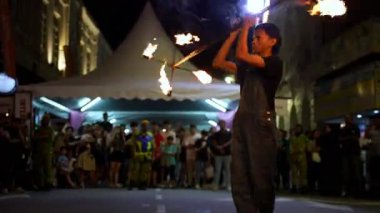 George Town, Penang, Malaysia - Nov 03 2024: A man is holding a flaming stick and is surrounded by a crowd of people