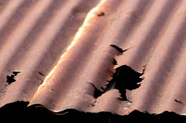 The old roof made of zinc is rusty and damaged. clipart