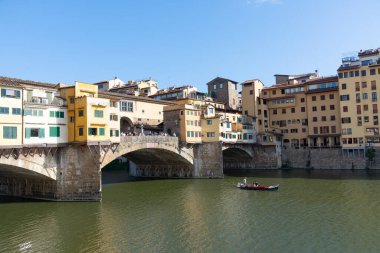Firenze, İtalya - 6 Ağustos 2023: Arno Nehri turist teknesi ve Ponte vecchio köprüsü manzaralı