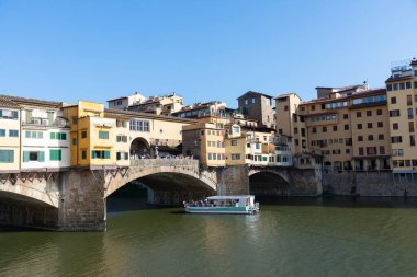 Firenze, İtalya - 6 Ağustos 2023: Arno Nehri turist teknesi ve Ponte vecchio köprüsü manzaralı