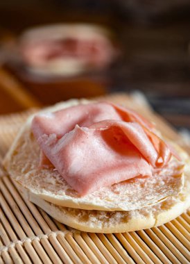 Close-up of delicious stack of crescentine tigelle with mortadella and rocket on a wooden board, ready to be enjoyed clipart