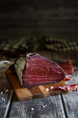 Kırsal arka planı olan ahşap bir tahtanın üzerinde duran et lezzeti.