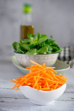 Taze rendelenmiş havuç ve mısır salatası, sağlıklı ve lezzetli bir yemek için malzemeler.