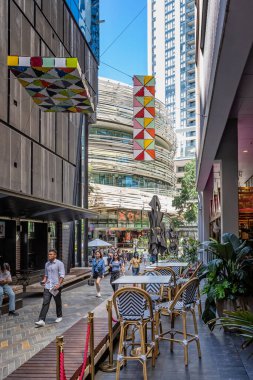 28 Aralık 2022 'de Darling Square, Sydney, NSW, Avustralya yakınlarındaki The Exchange binasının yanındaki yaya geçidinde dükkanlar ve kafeler
