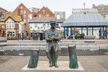Bronze Statue of seated Robert Baden-Powell, founder of the scouting movement, at The Quay, Poole, Dorset, UK on 13 February 2023