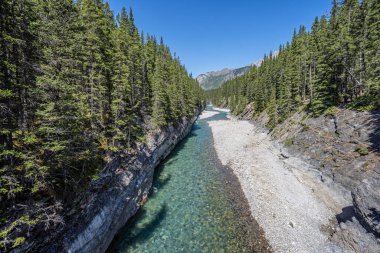 Stewart Canyon köprüsünün altından akan buzul çağlayan nehri Minnewanka Gölü, Banff, Alberta, Kanada