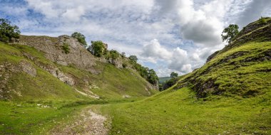 Peveril Castle seen from the Cavedale limestone valley in the High Peak District, Castleton, Derbyshire, UK on 25 July 2023 clipart