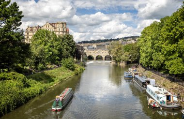 Avon Nehri 'ndeki Kanal Teknesi 16 Ağustos 2023' te İngiltere 'nin Bath kentindeki Pulteney Köprüsü' ne doğru ilerliyor.