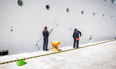 Two crewmen painting exterior of P&O Cruise ship Arvia in port at Alicante, Spain on 29 August 2023 clipart