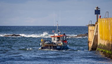 21 Eylül 2023 'te Eyemouth, Berwickshire, İskoçya' daki dalgalı denizlerde Eyemouth limanından ayrılan balıkçı teknesi.