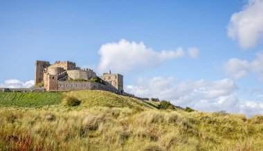 Bamburgh Kalesi 'nin 25 Eylül 2023' te Bamburgh, Northumberland 'daki kum tepelerinden yükselen kıyı manzarası