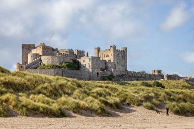 Bamburgh Kalesi 'nin 25 Eylül 2023' te Bamburgh, Northumberland 'daki kum tepelerinden yükselen kıyı manzarası