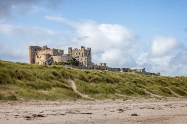 Bamburgh Kalesi 'nin 25 Eylül 2023' te Bamburgh, Northumberland 'daki kum tepelerinden yükselen kıyı manzarası