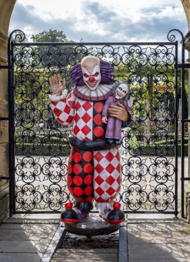 Cadılar Bayramı için Alnwick Gardens, Northumberland, İngiltere 'de 26 Eylül 2023' te şeytani gülümsemeli korkunç bir palyaço sergileniyor.