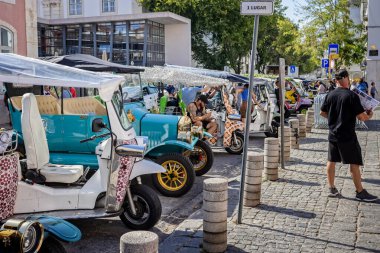 12 Ekim 2023 'te Lizbon, Portekiz' de turistleri bekleyen çeşitli tuk tukları.